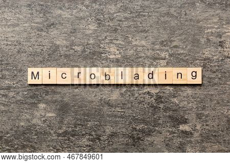 Microblading Word Written On Wood Block. Microblading Text On Cement Table For Your Desing, Concept.