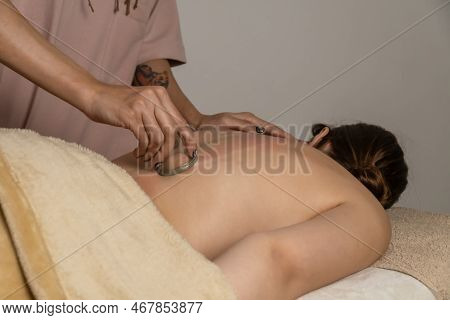 Massage Therapist At The Spa Does A Massage With A Vacuum Jar On The Back Of His Client For A Healin