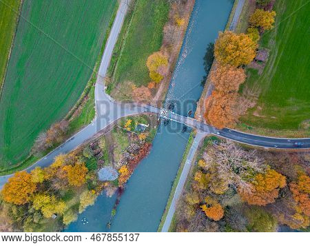 Top View Of Dark Autumnforest Landscape Wallpaper Art. Aerial Nature Scene Of Pine Trees And Road Ba
