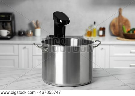 Pot With Sous Vide Cooker On Table In Kitchen. Thermal Immersion Circulator