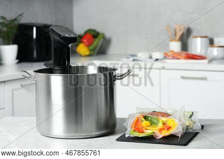 Pot With Sous Vide Cooker And Vacuum Packed Food Products On Table In Kitchen. Thermal Immersion Cir