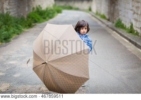 Little Handsome Baby Boy Playing With Umbrella Outdoor In Old Town. Boy Wearing Blue Jacket