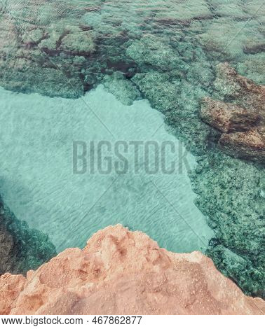 Rocky Seabed With Blue Water And White Sand. Mediterranean Sea Coast. Lagre Stones In The Water, Ver