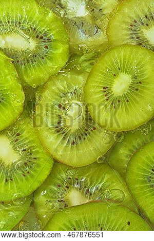 Close-up Fresh Slices Of Juicy Kiwi Fruit On White Background. Slices Of Kiwi Fruit In Sparkling Wat