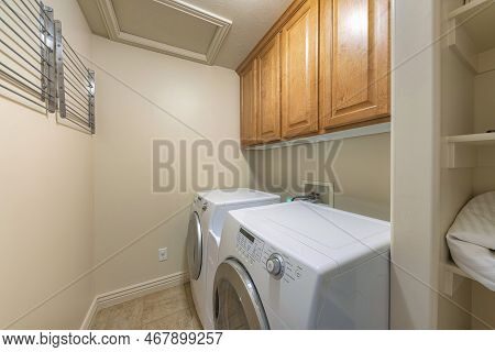 Small Laundry Room Interior With Wall-mounted Drying Rack. There Are Laundry Appliances On The Right