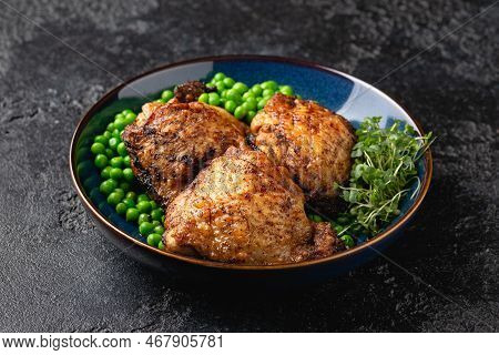 Baked Chicken Thighs With Green Peas In Blue Plate