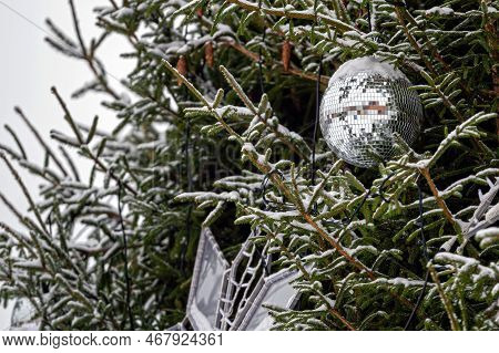 Christmas Disco Ball Decoration On A Snowy Fir Tree Branch. Selective Focus, Shallow Depth Of Field
