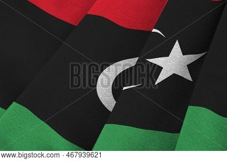 Libya Flag With Big Folds Waving Close Up Under The Studio Light Indoors. The Official Symbols And C