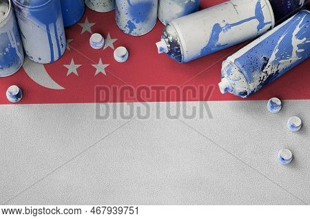 Singapore Flag And Few Used Aerosol Spray Cans For Graffiti Painting. Street Art Culture Concept, Va