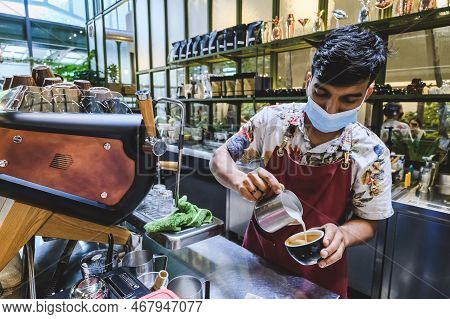 Kuala Lumpur, Malaysia - Februry 23, 2022: Professional Barista Poured Hot Milk Into A Hot Espresso 