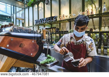 Kuala Lumpur, Malaysia - Februry 23, 2022: Professional Barista Poured Hot Milk Into A Hot Espresso 