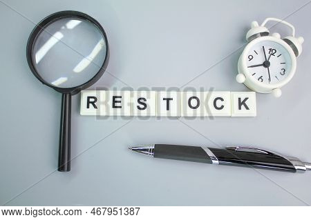 A Magnifying Glass, An Alarm Clock And A Pen With A Restock Of Alphabet Words. The Concept Of Refill