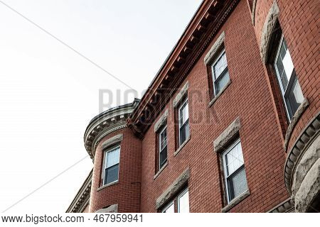 Oblique View Of Brick Apartment Building With Rusticated Stone Window Lintels  And Dentil Trim Detai
