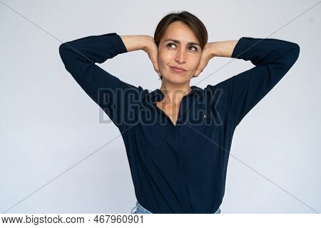 Uninterested Woman Covering Ears. Female Model In Dark Blue Shirt Not Listening To Something, Lookin