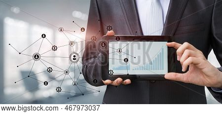 Businessman Showing Financial Growth Charts On Blurred Office Background.