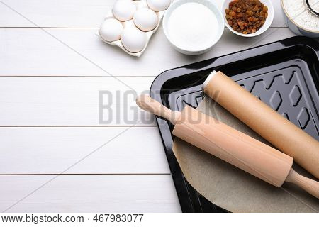 Baking Pan With Parchment Paper, Different Ingredients And Kitchen Tools On White Wooden Table, Flat