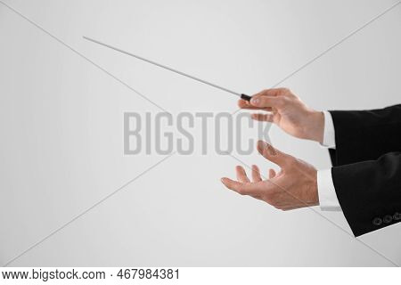 Professional Conductor With Baton On Light Grey Background, Closeup. Space For Text