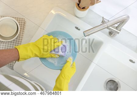 Man Washing Plate In Kitchen Sink, Top View