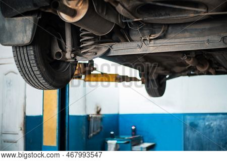 Car On A Lift In A Car Repair Shop. Repair And Diagnostics Of The Chassis. Foreground. Selective Foc