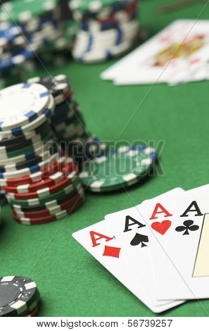 Poker de ases y juego de chips apilados en una mesa