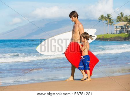 Father and Son Going Surfing Together on Tropical Beach in Hawaii