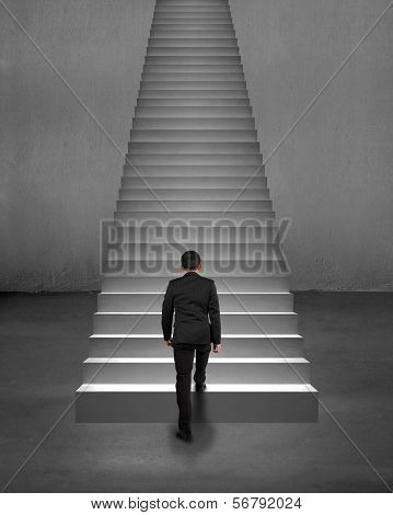 Rear View Businessman Climbing On Stairs With Spot Lighting