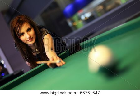 Young brunette girl playing snooker