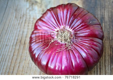 Big red onion on wooden table
