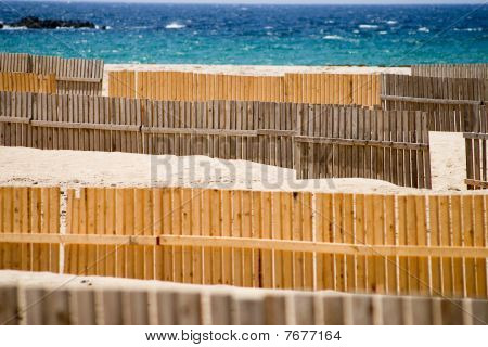 Plage de sable de Tarifa avec sable-clôtures en bois contre le ciel bleu et mer turquoise
