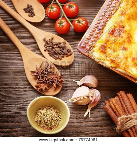 ready lasagna and its ingradient on a wooden table