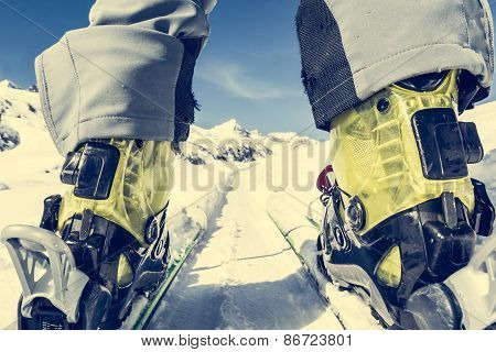 Close Up Of Skier's Boots And Skis From Ground Level.