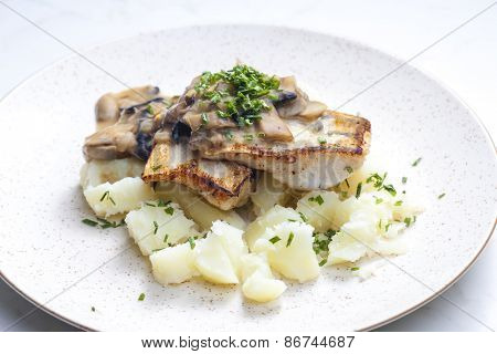 pikeperch on butter with mushroom sauce and spring potatoes