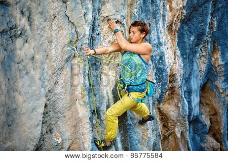 Rock climber climbing up a cliff