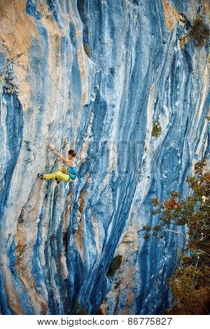 Rock climber climbing up a cliff