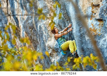 Rock climber climbing up a cliff