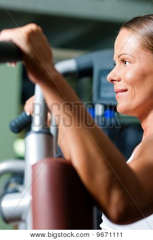 Kvinna i gymmet på maskin utövar