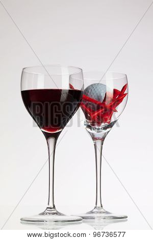Wine Glasses With Red Wine And Golf Ball