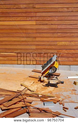 Ipe wood fence installation with carpenter table circular saw and sawdust