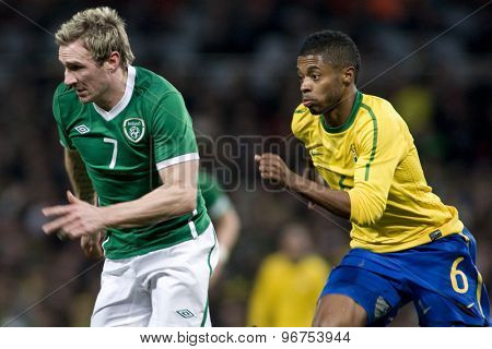 LONDON, ENGLAND. March 02 2010: Ireland's Liam Lawrence and Brazil's Michel Bastos during the international football friendly between Brazil and the Republic of Ireland played at the Emirates Stadium.