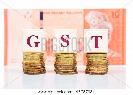 GST or Goods and Services Tax concept with stack of coins and Malaysia Ringgit currency as backdrop