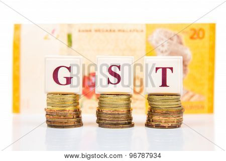 GST or Goods and Services Tax concept with stack of coins and Malaysia Ringgit currency as backdrop