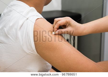 Medical doctor swap arm of patient with alcohol before vaccination
