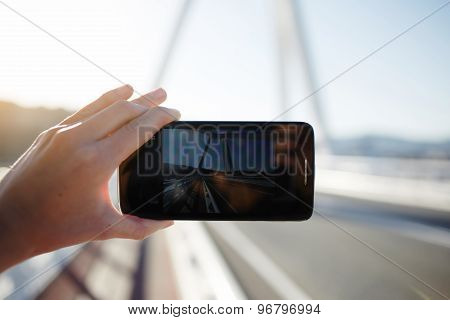 Person taking a photo of beautiful sunset using smart phone camera of outdoors