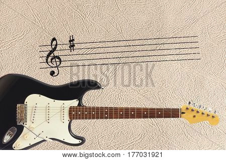 Notes stave and solid body classic electric guitar at the bottom of the light skin background.