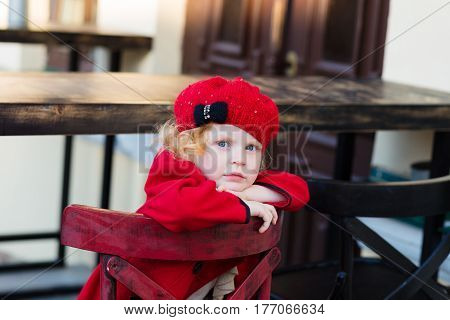 Portrait Of A Beautiful Little Girl With Red Hair In A Red Coat