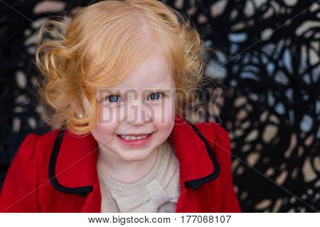 Portrait Of A Beautiful Little Girl With Red Hair In A Red Coat