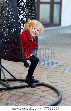 Portrait Of A Beautiful Little Girl With Red Hair In A Red Coat