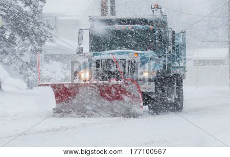 Snow plow clearing the road during a blizzard
