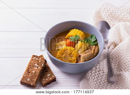 Puchero Soup With Corn And Parsley On Wooden Table