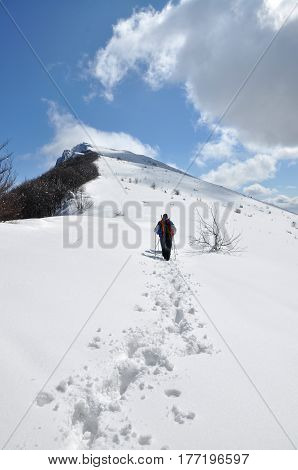 Beautiful dynamic sky above dry mountain peak Trem in Serbia. Winter landscape on mountain. Mountaineer going to the top through the snow